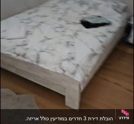 מיטה עם מצעים ודברים מונחים עליה